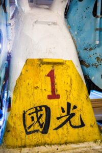 Kaohsiung-Dragon-Boat-1989 Close-up of the colorful, worn paint and markings on the front of a dragon boat, with the number "1" and Chinese characters.