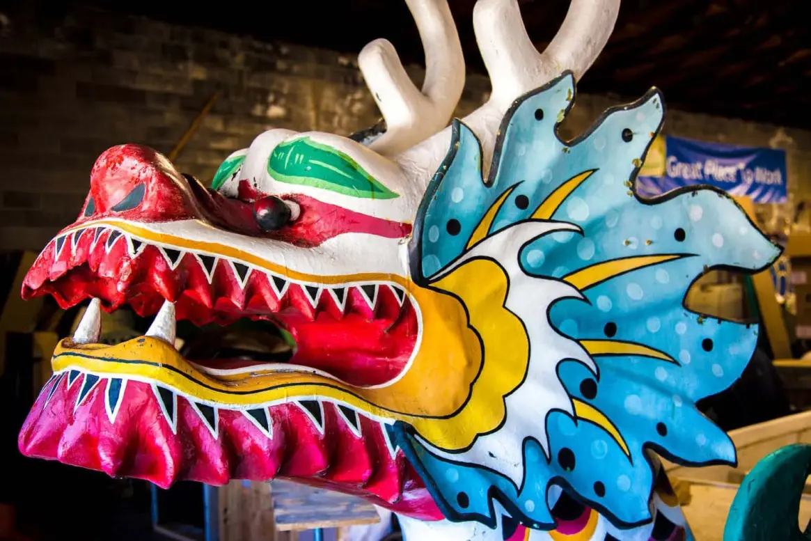 Close-up of a vibrant, hand-painted dragon boat head with bold colors and intricate details.