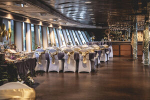 Inside the Portland Spirit with white chair covers and purple and gold sashes