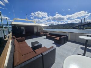 Sunny deck photo of the Willamette Star next to the Willamette River